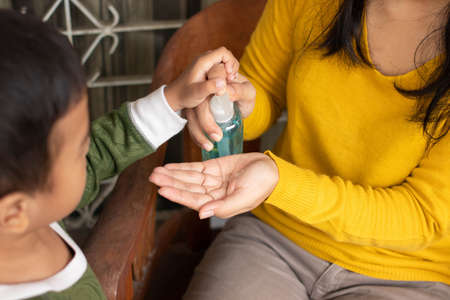 a mother uses antiseptics for her son at home, so his son is protected from bacteria and viruses