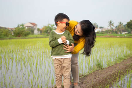 Asian mothers and children are joking around the fields cheerfullyの写真素材