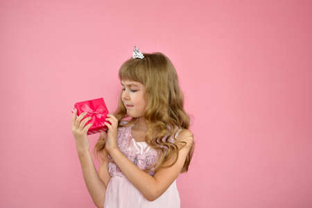 Girl cheerfully posing on a pink background.の写真素材
