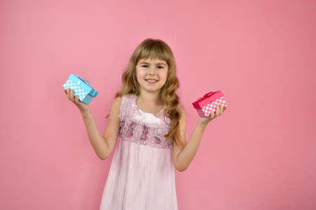 Girl cheerfully posing on a pink background.