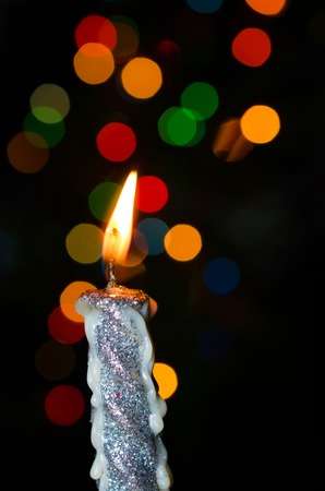 Christmas candle with background of colorful bokehの写真素材