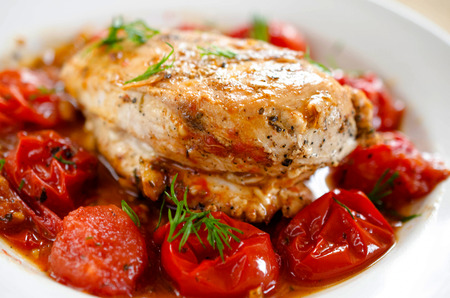Close up of Fried chicken fillet with garnish of tomatoの写真素材