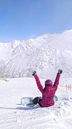 Girl with snowboard siting at the Caucasus Mountains,Elbrus