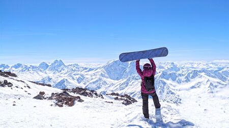 Girl with snowboard standing at the Caucasus Mountains,Elbrusの写真素材