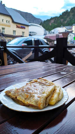 Tasty khychin on white plate over background of hotels and mountains. Cafe of caucasian cuisine at station AZAU. Elbrusの写真素材