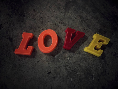 the colorful alphabets in LOVE concept on cement wall in abstract design,blurry light aroundの写真素材