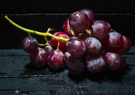 Grape put on black timber board,fresh fruit,in abstract art design,vintage and art styleの写真素材