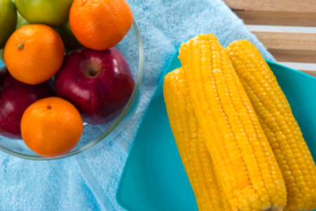 the blurry light design background of red apple,green apple ,orange and yellow corn,healthy fruit,good for healthの写真素材