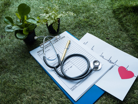 The Stethoscope and red heart with cardiogram  of heart rate drawing on paper,with Insurance Claim...