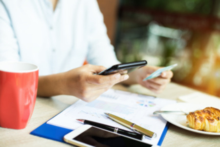 The blurred design background of  lady is using mobile phone for shopping online and payment by...