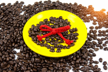 In selective focus of yellow ceramic dish with coffee bean and red rope,blurry light aroundの写真素材
