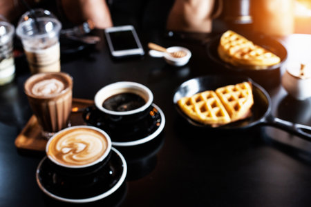 The blurry light design background of coffee cup and waffle on table,at coffee shopの写真素材