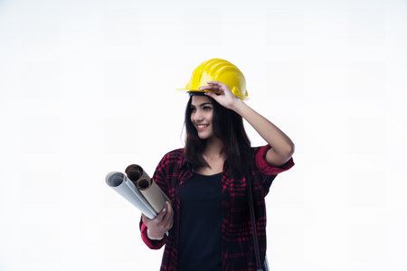 The young woman engineer with yellow safety helmet and hold blueprint in her handの写真素材