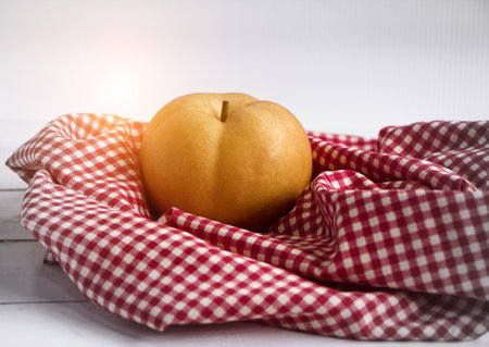 The Chinese pear put on table cloth,warm light tone,blurry light aroundの写真素材