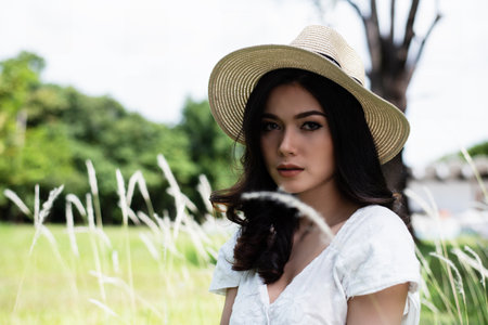 The beauty lady with white dress in garden,model posing,with little smile,blurry light design backgroundの写真素材