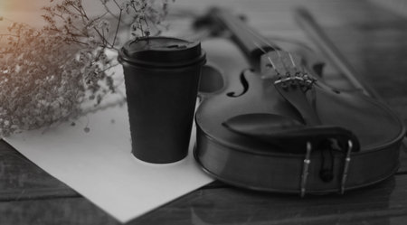 The classic violin and bow put on wooden timber ground floor,beside black coffee cupの写真素材