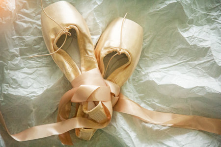 The pink ballet shoes on background