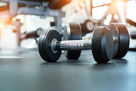 The dumbbell put on ground floor,at fitness gym,blurry light around