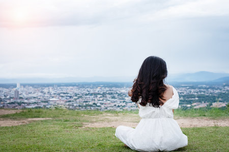 The beauty lady is wearing white dress ,sitting in a park,relax timeの写真素材