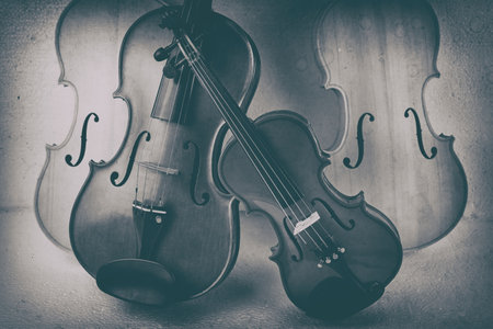 The abstract art design background of two violins put at the middle of raw violin,art tone,blurry light aroundの写真素材