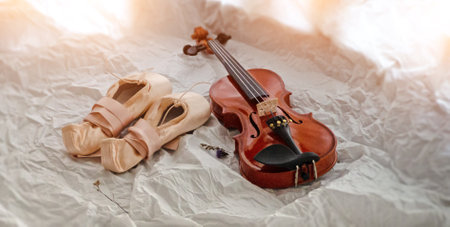 The ballet shoes and violin put on background,warm light tone,blurry light around.の写真素材