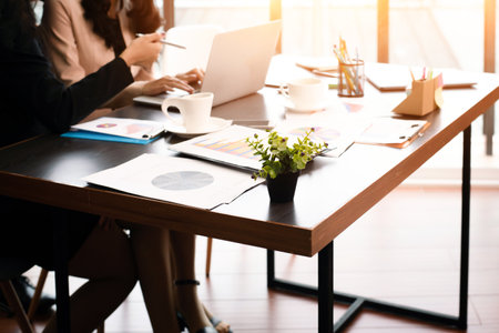 The blurry light design background of business workers are working  in office hour,plenty of business paper chart on table,warm light tone.の写真素材
