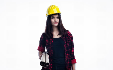 The young woman engineer is wearing yellow safety helmet and hold blueprint in her handの写真素材