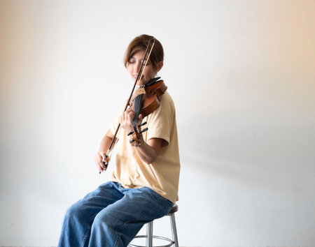 Woman holding violin and bow in hand,prepare for practice,blurry light aroundの写真素材