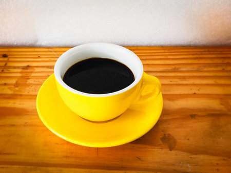 Single Yellow coffeecup put on wooden table.black aroma Hot drink.の写真素材