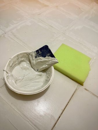 White grout in bow and  spreader prepare for Groove tile floor ,repairing and maintenance house