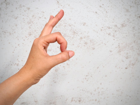 Symbol of OK,success deal,positive hand sign,body language in front of background,blurry light around.の写真素材