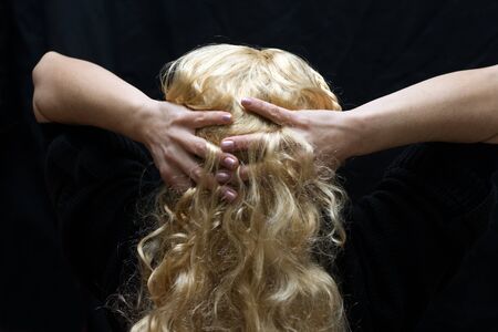 Blonde mature woman with hands in the hairsの写真素材
