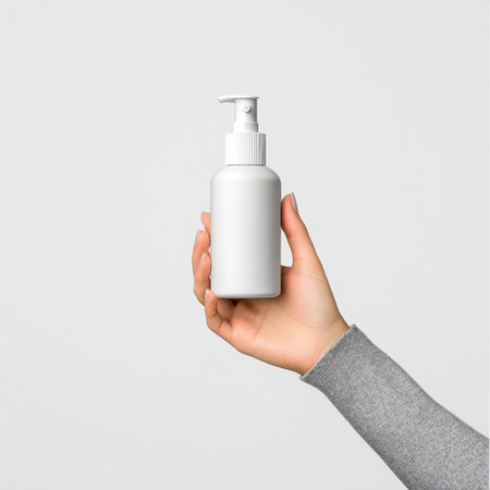 Hand Holding A White Pump Bottle On A Neutral Background For Beauty Or Skincare Useの素材