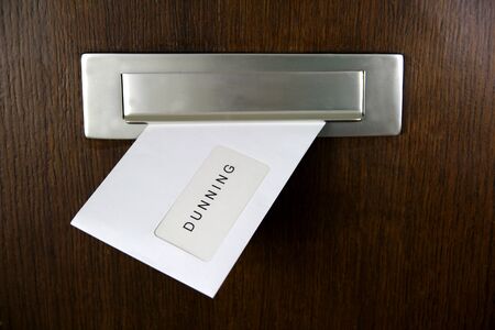 A letter in a letterbox of a door, written DUNNINGの写真素材