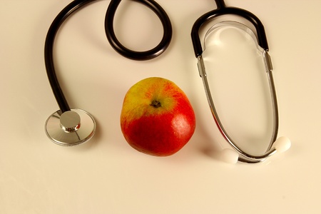 Stethoscope with apple on a table stands for healthy foodの写真素材