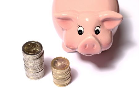 Pink Piggy bank watching two Euro coinstacksの写真素材
