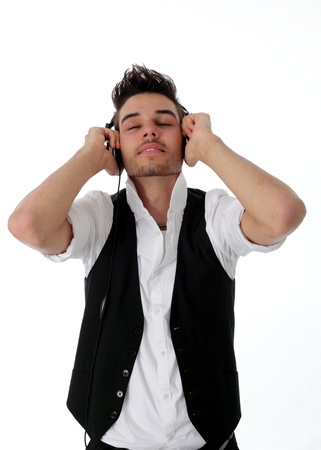 Young man wearing earphones smiling contentedly with his eyes closed as he is enraptured by his musicの写真素材