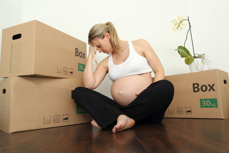 Exhausted Pregnant Moving with packing caseの写真素材