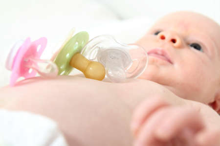 A Baby wirh diferent orthodontic Pacifiers 