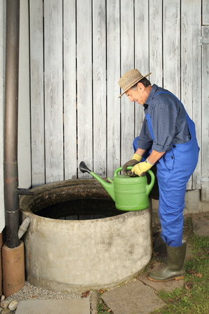 A Gardener next to his Rain water barrelの写真素材