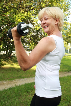 A Elderly woman outdoor training with dumbbellの写真素材