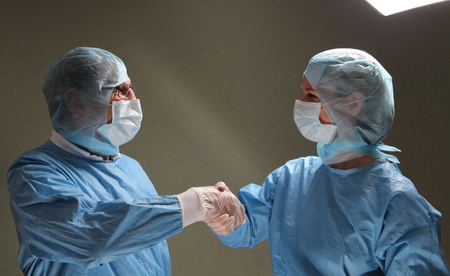 Two OP doctors shaking hands after successfull workの写真素材