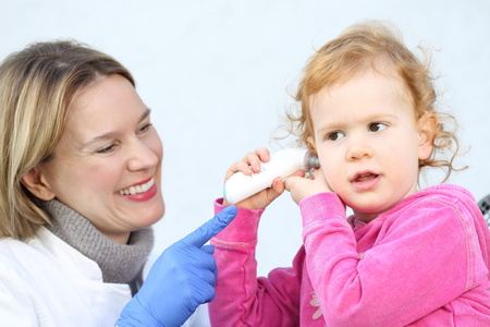 A Doctor measuring with InfraredThermomete temperature  a Child