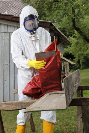 A Worker with mask packing Asbestos Disposal