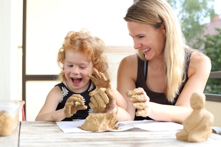 A Child and mother having fun doing creative potteryの写真素材
