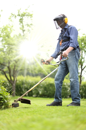 A Man working with a Brushcutter in his garden