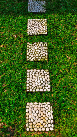 Square stepping stone used pathway on the grass at home garden or park.の写真素材