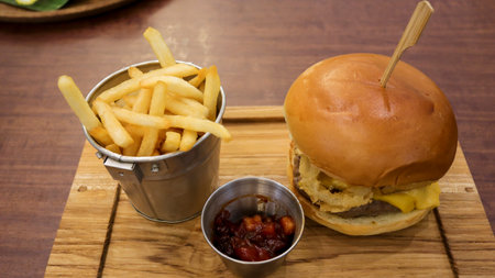 Beef brisket burger and straight cut fried potato stick, French fries and some sauce.の写真素材