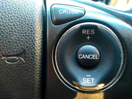 Cruise control button in conventional modern car. Car instrument panel, interior dashboard control.