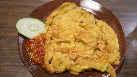 A plate of omelette egg with deep fried cook and traditional sambal or mashed chili sauce. Indonesian style cuisine.の写真素材